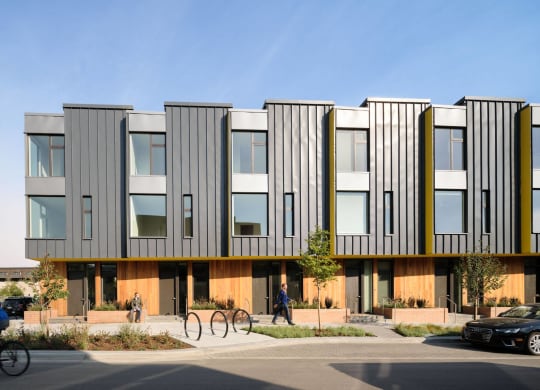 a rendering of a building with a person riding a bike in front of it