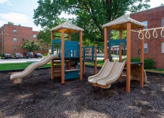 a playground with two slides and a swing set