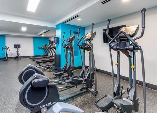 a gym with various exercise equipment in a room
