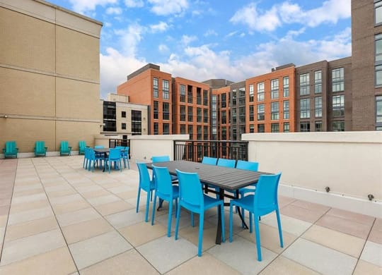a patio with a table and chairs on top of a building