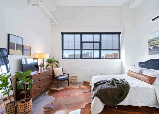 a bedroom with a bed and a large window