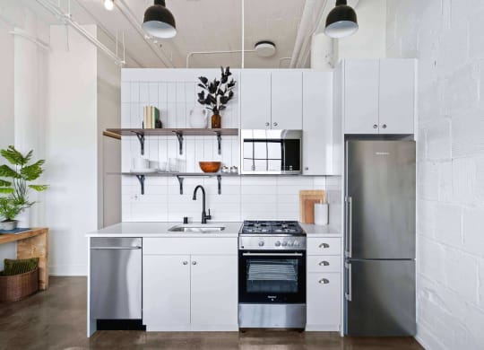a kitchen with white cabinets and a stainless steel refrigerator