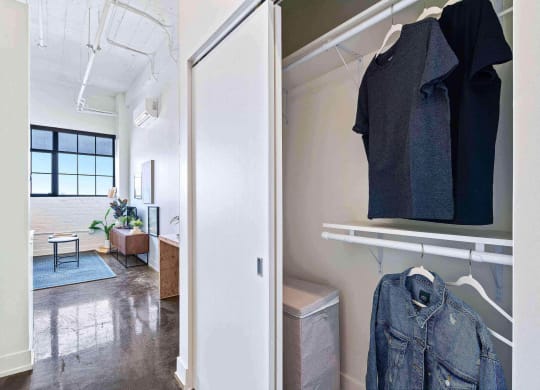 a living room with a closet and a jacket hanging on the wall