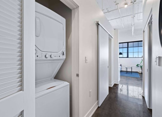 a laundry room with a washer and dryer and a hallway with a door