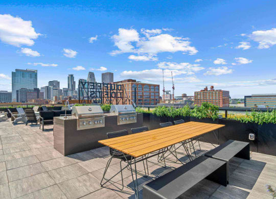 a rooftop patio with a view of the city and a picnic table