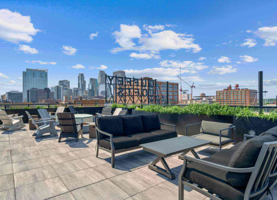 a roof top patio with chairs and tables and a view of the city