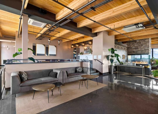 a lobby with couches and tables and a kitchen