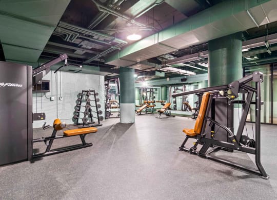 a gym with weights and exercise equipment in a building