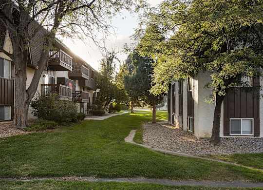 Trailgrove Apartments community grounds on South Quebec Street with mature trees and shaded lawn areas
