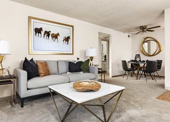 Cozy living room with neutral paint and natural light at Trailgrove Apartments on South Quebec Street in Southeast Denver.
