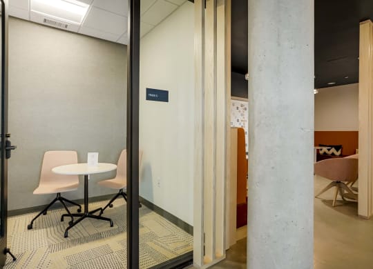 a conference room with glass doors and a table and chairs