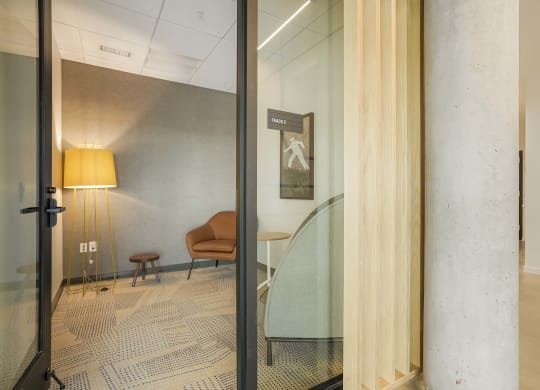 a glass wall in a room with a glass table and a chair