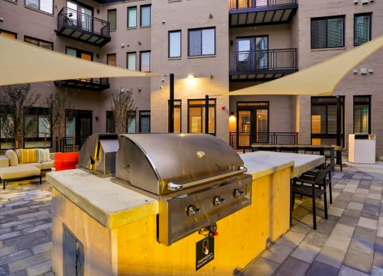 Pet-Friendly Apartments In Wheat Ridge, CO - The Parallel - Grill Area With BBQs, Couches, Tables, And Chairs