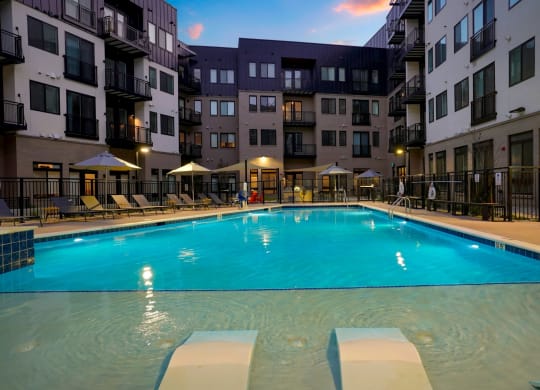 a large swimming pool in front of an apartment building
