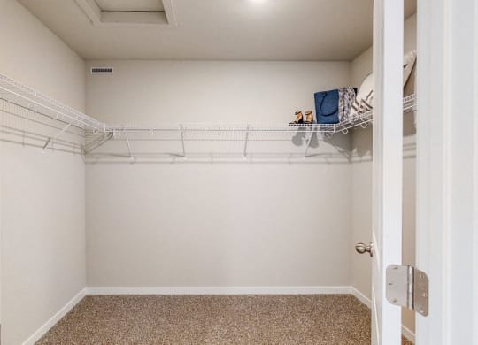 an empty closet with a white wall and a white closet door