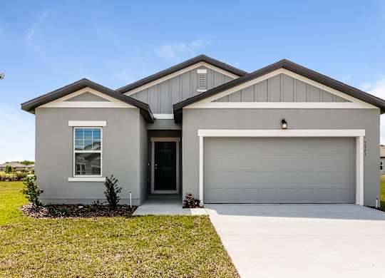 A two-story house with a garage door and a window.
