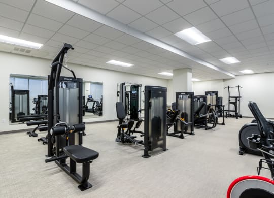 a fitness room filled with exercise equipment and weights