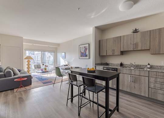 A modern kitchen with a dining table and chairs.