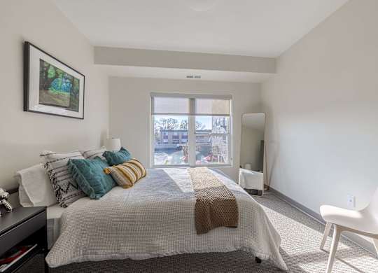A bedroom with a large bed and a chair.