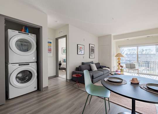 A modern kitchen with a washer and dryer built into the cabinetry.