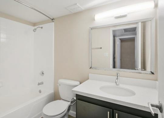 Bathroom with tub, shower, and large mirror at Sentry Tempe apartments in Tempe near Mesa, Arizona