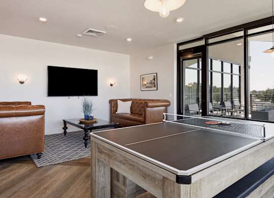A ping pong table is in the middle of a living room.