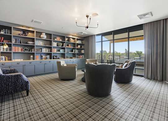 A room with a checkered floor and a bookshelf filled with books.
