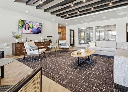 A modern living room with a large screen TV mounted on the wall.