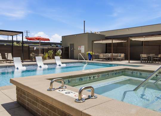 A pool with a blue tiled edge and a metal ladder.