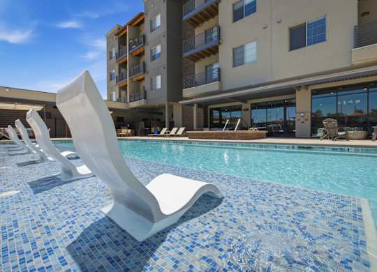 A pool with a blue tiled edge and a white sculpture in the middle.