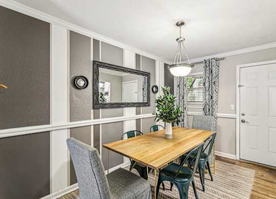 A dining room with a wooden table and grey chairs.