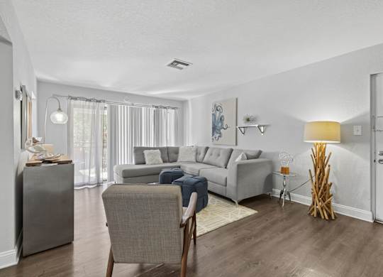 A living room with a grey couch and a chair.