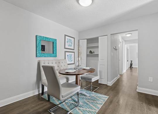 A dining room with a table and chairs.