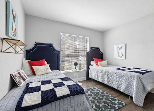 A bedroom with two beds and a window.