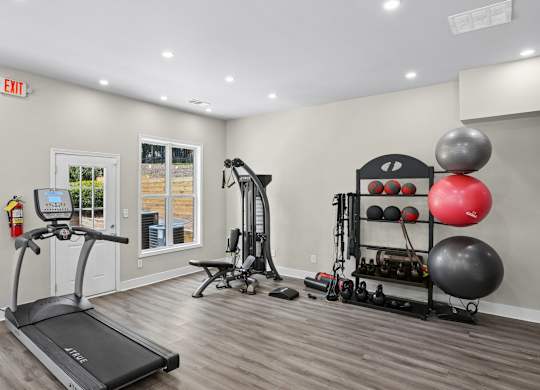 A gym room with a treadmill, weights, and exercise equipment.