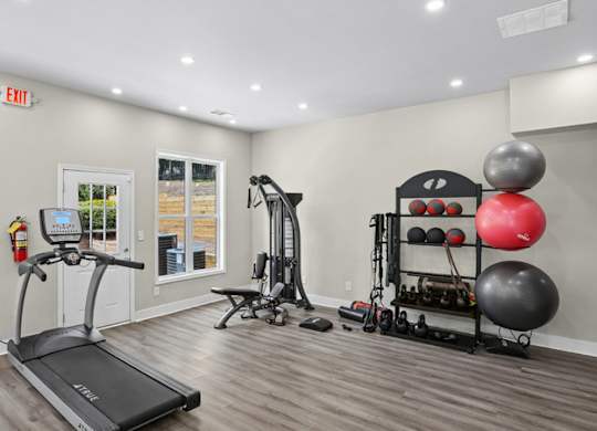 A gym room with a treadmill, weights, and exercise equipment.