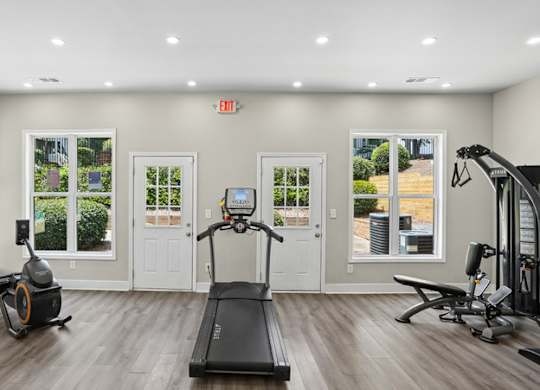 A spacious home gym with a treadmill, elliptical trainer, and stationary bike.