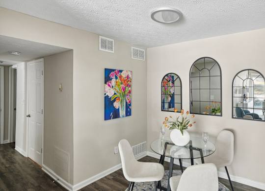A dining room with a glass table and chairs.