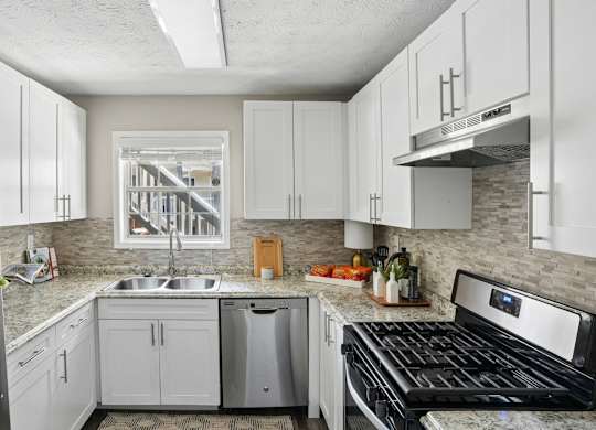 A kitchen with white cabinets and a black stove top oven.
