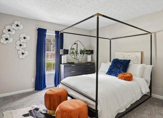 A bedroom with a white bed and a black metal frame.