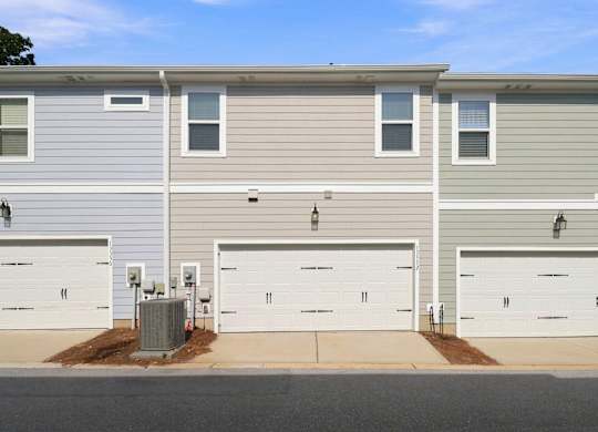 A row of houses with garages and driveways.