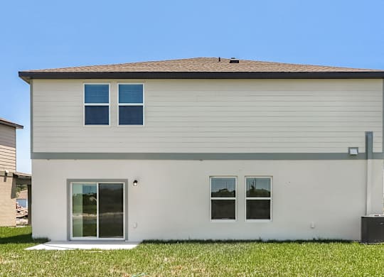 A small house with a grey roof and white walls.