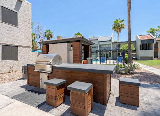 Community outdoor kitchen at Sono Tempe Apartments featuring built-in grills and seating in Tempe, AZ.