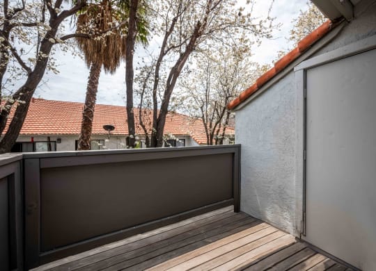 a balcony with a view of trees and a house