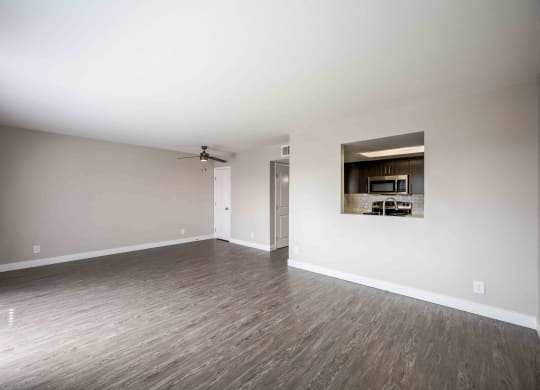 an empty living room with white walls and wood floors