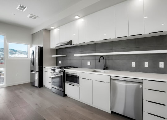 a kitchen with white cabinets and stainless steel appliances