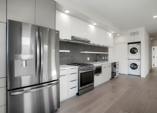 a kitchen with white cabinetry and stainless steel appliances