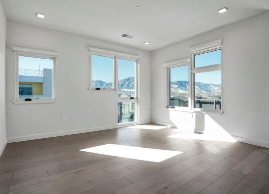 a bedroom with hardwood floors and white walls