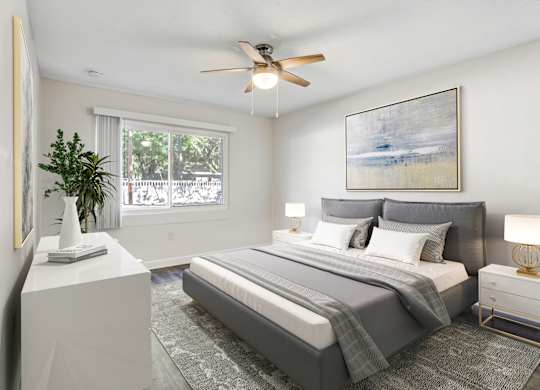 Bedroom with large window, natural light, and ceiling fan at Square One Apartments in Gainesville FL