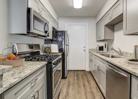Kitchen with stainless steel appliances and ample cabinet space at Square One Apartments in Gainesville FL